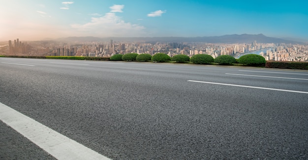 Carretera de asfalto vacía y horizonte de la ciudad y paisaje de construcción, China.