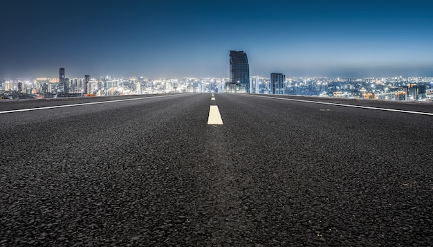 Carretera de asfalto vacía y horizonte de la ciudad y paisaje de construcción, China.