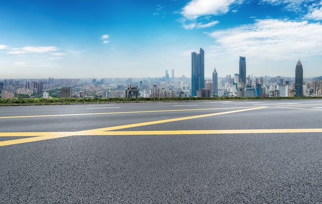 Carretera de asfalto vacía y horizonte de la ciudad y paisaje de construcción, China.