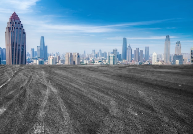 Carretera de asfalto vacía y horizonte de la ciudad y paisaje de construcción, China.