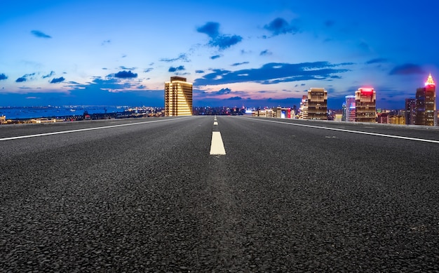 Carretera de asfalto vacía y horizonte de la ciudad y paisaje de construcción, China.