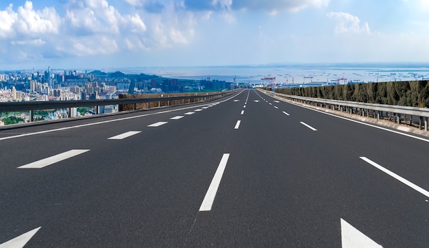 Carretera de asfalto vacía y horizonte de la ciudad y paisaje de construcción, China.