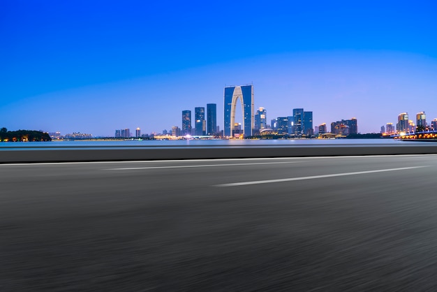 Carretera de asfalto vacía a lo largo de modernos edificios comerciales en las ciudades de China