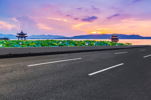 Carretera de asfalto vacía y paisaje natural en la puesta de sol