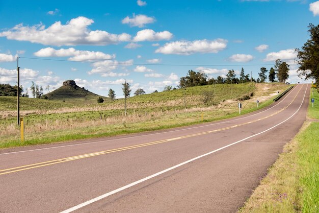 Una carretera sin automóviles y algunas colinas al fondo en Uruguay junto a Tacuarembó Vista clásica del cerro Batovi se puede ver en el horizonte