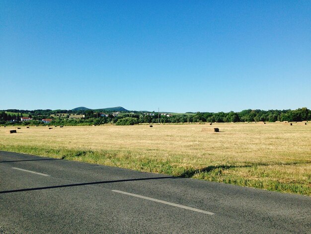 Foto carretera y campo contra un cielo azul claro en un día soleado