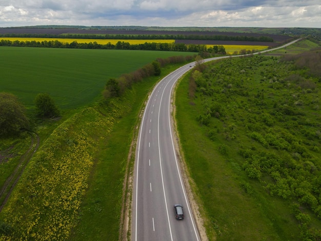 carretera con coches y campos verdes a lo largo de la carretera