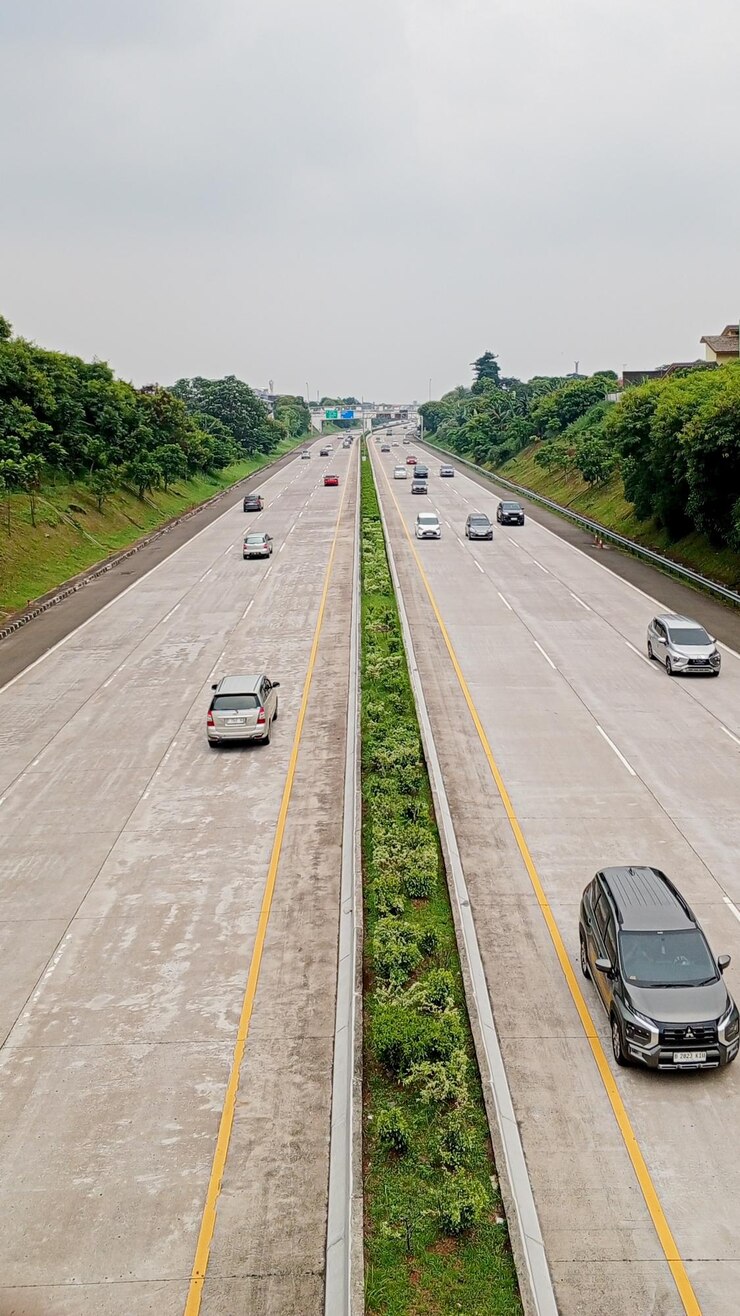 una carretera con coches conduciendo en ella y los árboles en el lado