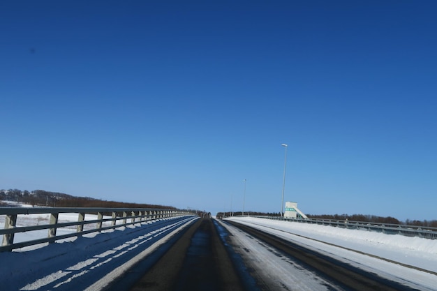 Foto carretera contra el cielo azul claro durante el invierno