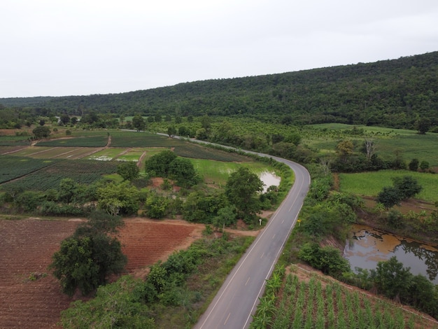 Carretera con curvas en tierras de cultivo rurales, fotografía aérea de drones.