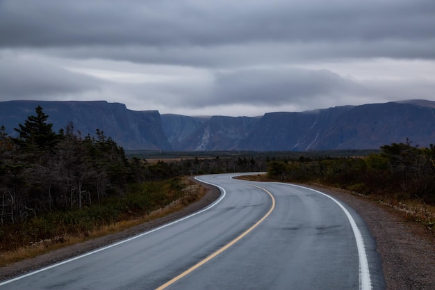 Carretera escénica con curvas en el paisaje canadiense durante una puesta de sol nublada