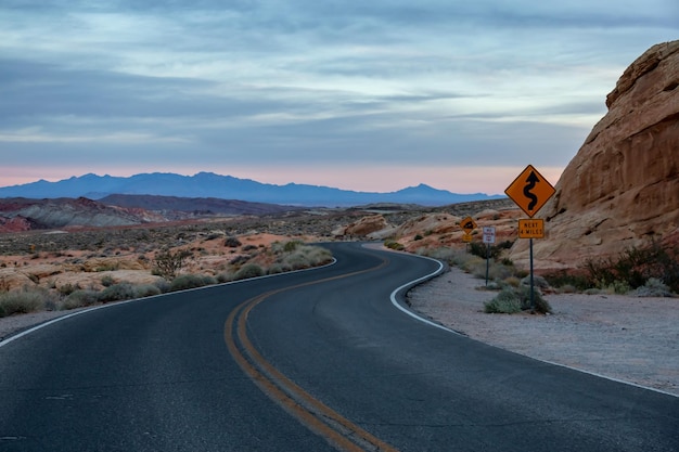 Carretera escénica en el desierto durante un amanecer nublado