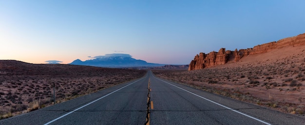 Carretera escénica en el desierto durante un vibrante amanecer soleado