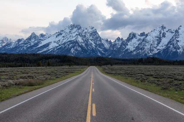 Carretera escénica rodeada de montañas y árboles en el paisaje americano.