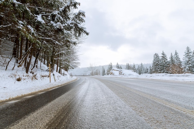 En la carretera hay hielo, la pista está nevada. Invierno helado. Árboles en la nieve.