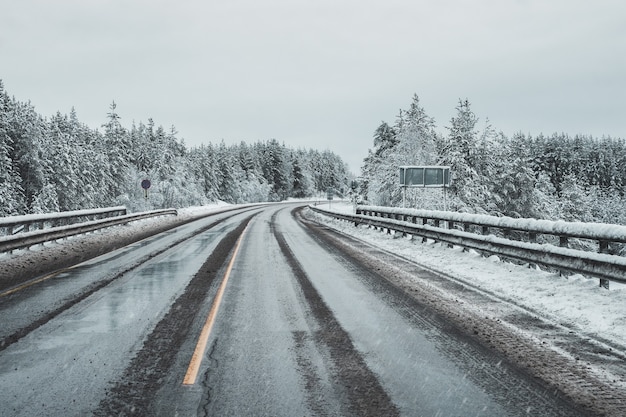 Una carretera de invierno sucia y vacía. Un giro en un camino resbaladizo.