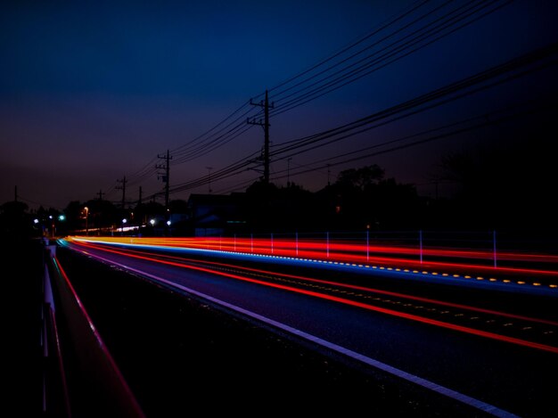 Una carretera con una luz de coche encendida y una valla al fondo.