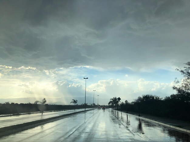 Foto carretera en medio de árboles contra el cielo durante la temporada de lluvias