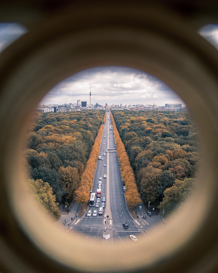 Foto carretera en medio de árboles vista a través de un agujero durante el otoño