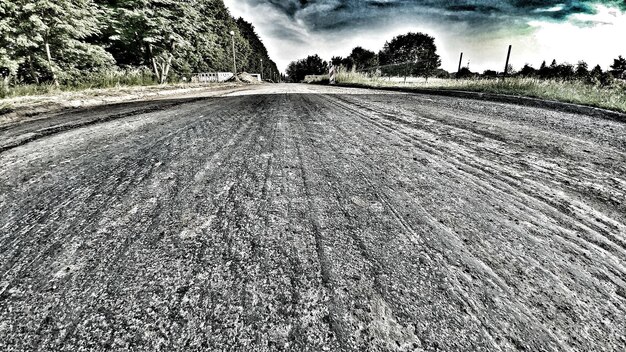 Foto carretera en medio de un campo agrícola contra el cielo