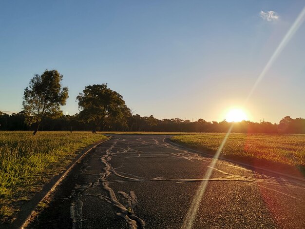 Foto carretera en medio de un campo contra el cielo durante la puesta de sol