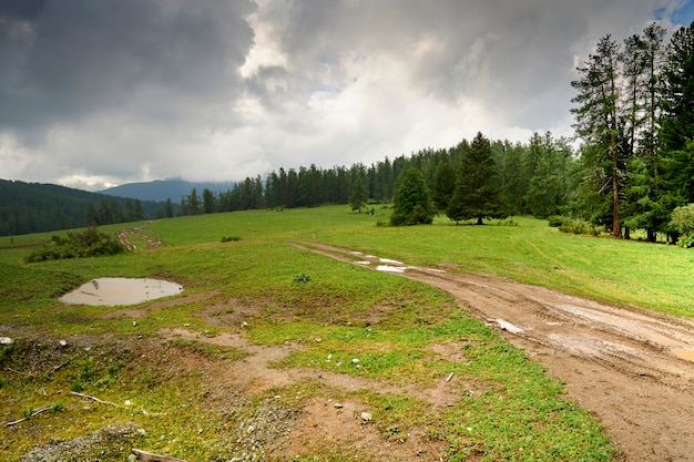 Carretera de montaña borrosa por las lluvias. todoterreno en las montañas. Sombrío cielo nublado y lluvia en las montañas. Altai