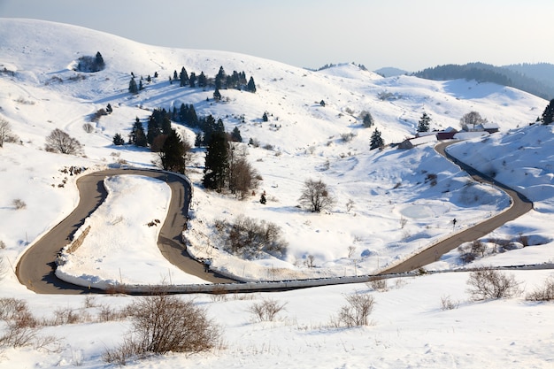 Carretera de montaña con curvas en temporada de invierno. Nieve y camino