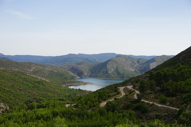 Foto una carretera de montaña en las montañas con un lago al fondo