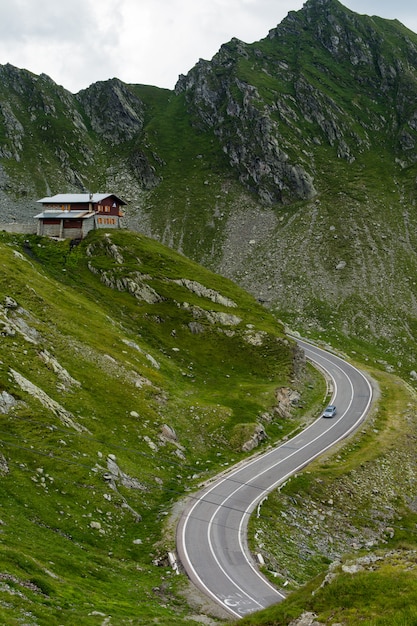 Carretera de montaña Transfagarasan con pequeño edificio en roca, Cárpatos rumanos