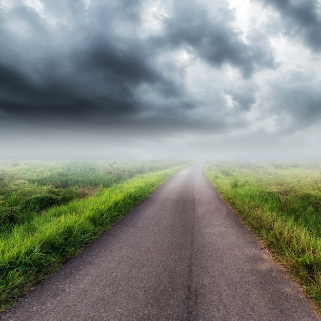 Carretera nacional en campo y nubes de tormenta o nubes de lluvia