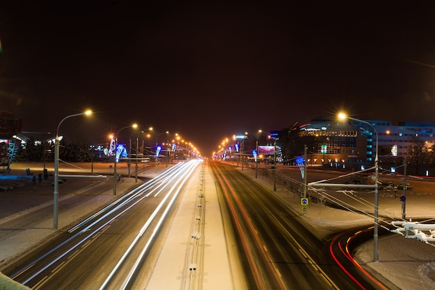 Carretera en la noche de invierno, ciudad, coches, luces, velocidad.