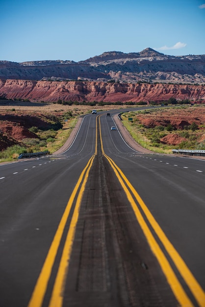 Carretera que atraviesa el paisaje árido del suroeste de Estados Unidos con neblina de calor extremo en un día caluroso y soleado con cielo azul en verano.