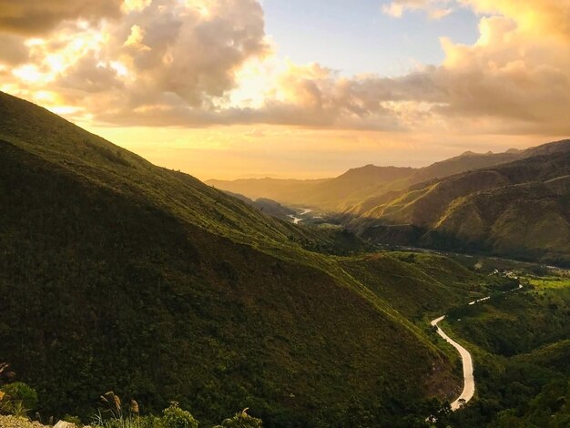 Carretera que corre entre montañas verdes