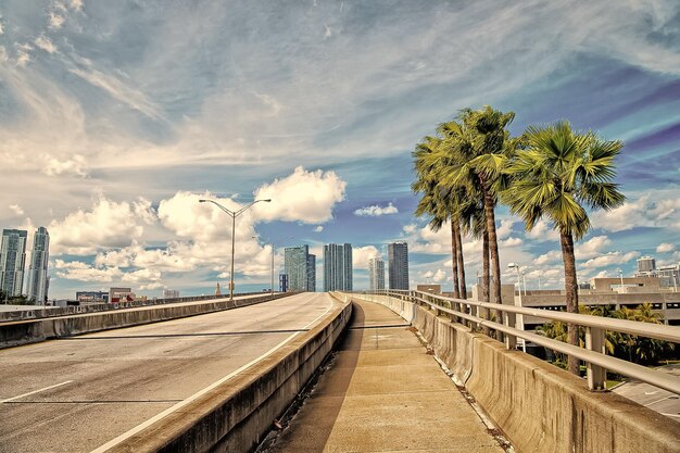 Carretera con rascacielos en azul cielo nublado