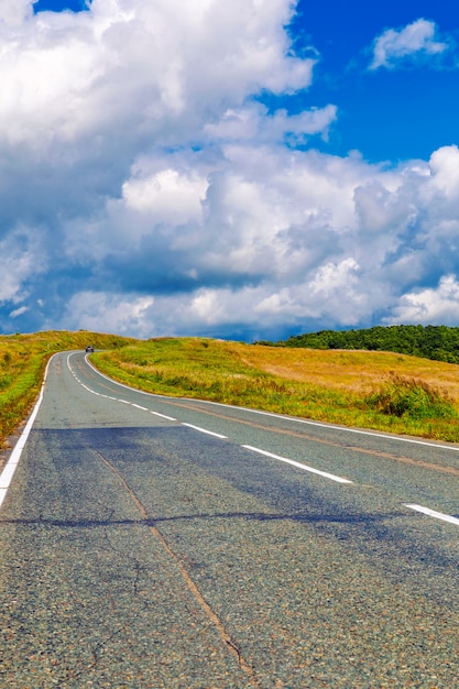 Carretera sinuosa y cielo azul nublado