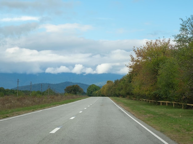 Carretera a través del bosque otoñal camino natural concepto camino al campo natural del bosque caucásico relajante con entorno ecológico Montaña Digoria es un parque nacional en Osetia del Norte