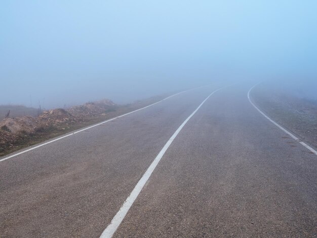 Carretera a través del paso en una espesa niebla