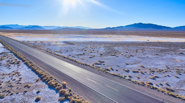 Carretera turística a través de llanuras desérticas planas con montañas