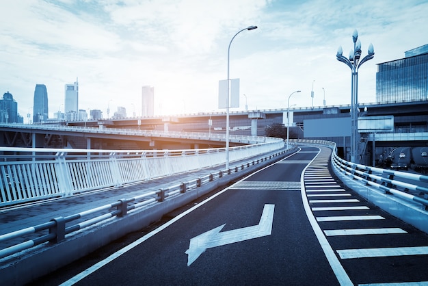 Carretera urbana, puente y horizonte de edificio urbano.