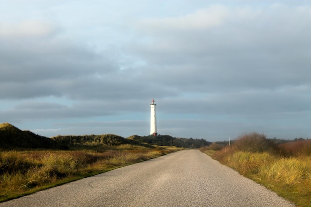 Foto carretera vacía con faro en el fondo