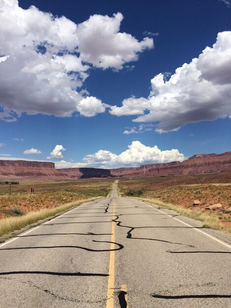 Foto carretera vacía con montañas en el fondo