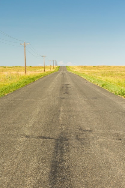 Carretera vacía a través de tierras de cultivo.