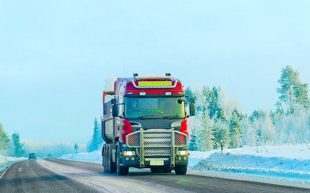 Carretilla en carretera de invierno de nieve de Finlandia. Camionero en carretera. Camión haciendo trabajo de logística. Semirremolque con conductor. Unidad de coche de carga grande. Entrega de carga. Industria del transporte de exportación. Contenedor con mercancías