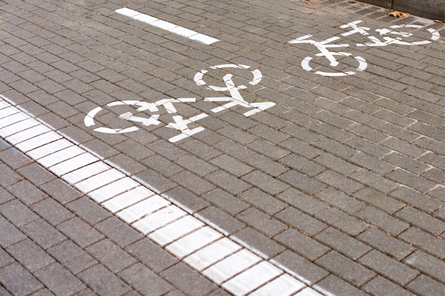 Carril bici de dos vías, marcando el carril bici en la acera, señal de bicicleta pintada de blanco en la carretera en la calle. Símbolo de bicicleta de carretera. Montar en bicicleta, andar en bicicleta, andar en bicicleta, ruedas y concepto de estilo de vida saludable