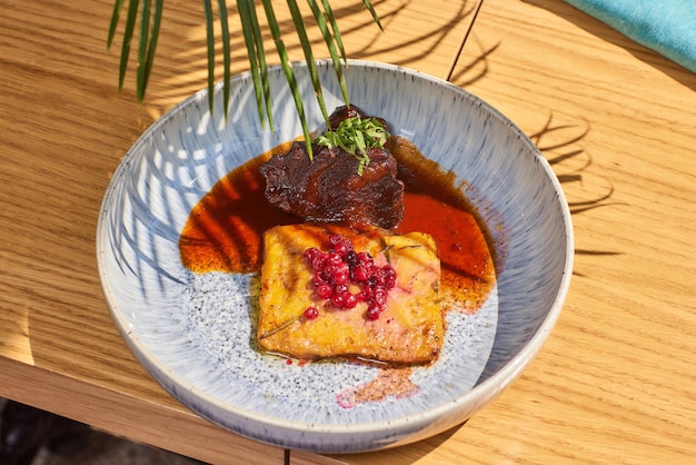 Carrillera de ternera caramelizada en salsa de vino con rebozuelos en un plato