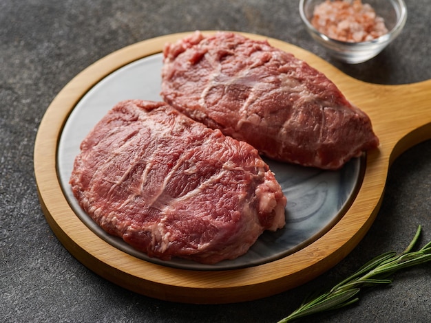 Foto carrilleras de cerdo frescas crudas con sal y pimienta preparando carne para la cena