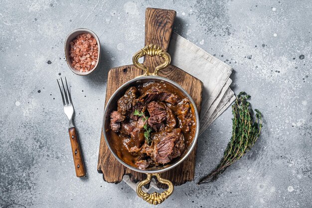 Carrilleras de ternera estofadas alemanas en salsa de vino tinto marrón Fondo gris Vista superior