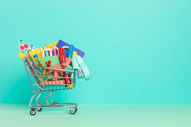 Carrinho de compras cheio de material escolar como preparação para a escola