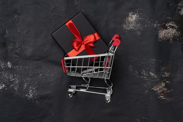 Carrinho de compras com caixa de presente e cope space em preto.