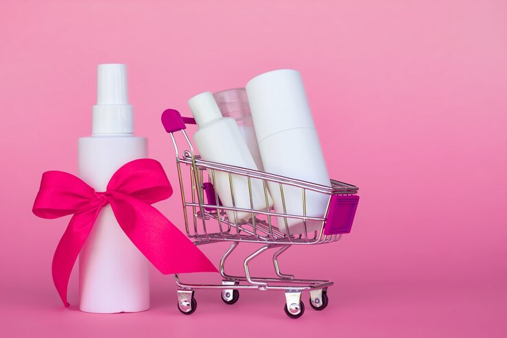 Carrinho de compras com frascos de cosméticos com fita rosa brilhante em fundo rosa. Copie o espaço.